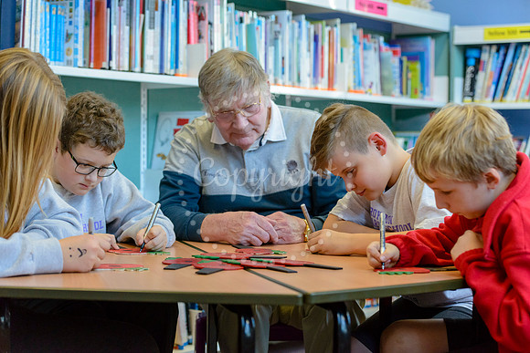 Roydon primary school pupils writing messages on painted wooden poppies