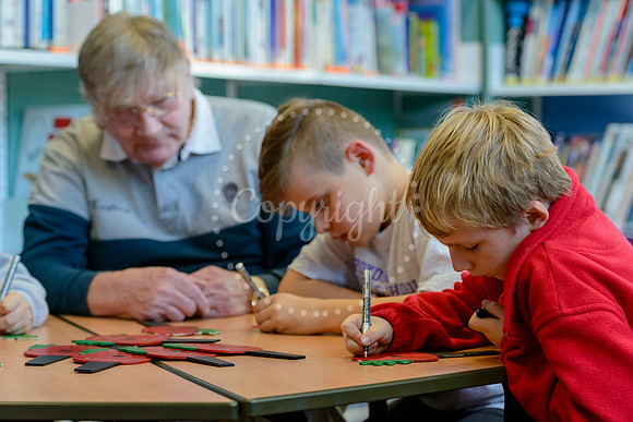 Roydon primary school pupils writing messages on painted wooden poppies