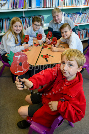 Roydon primary school pupils writing messages on painted wooden poppies