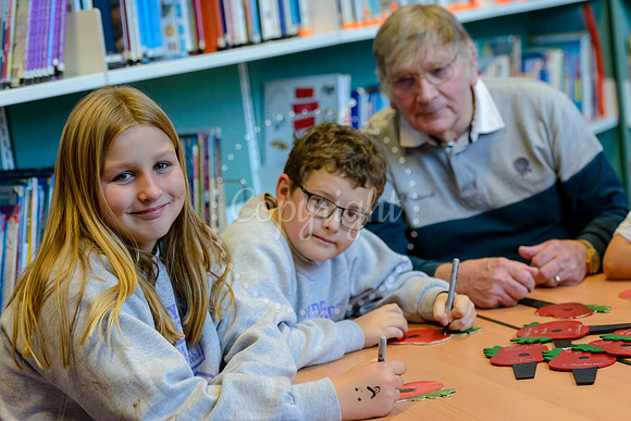 Roydon primary school pupils writing messages on painted wooden poppies